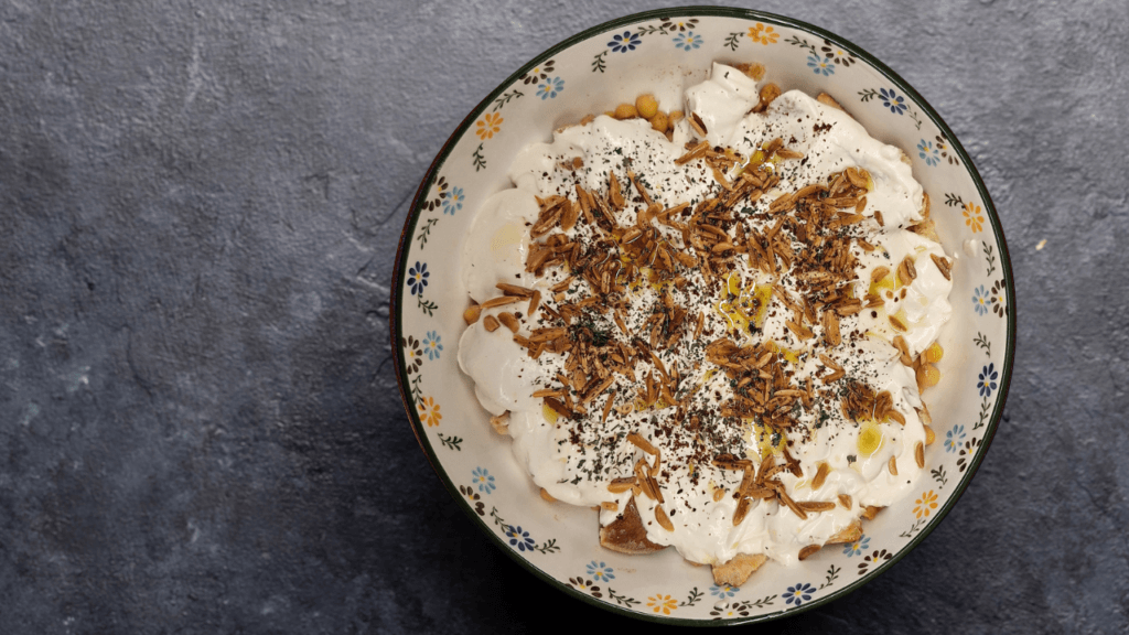 A Lebanese dish of toasted bread, chickpeas and creamy yogurt, finished with nuts and aromatic spices.